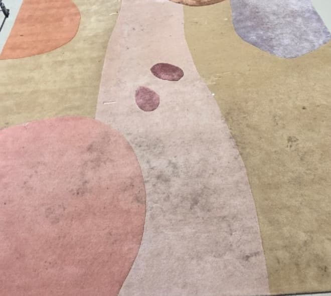 Design-matto ennen pesua — tummia tahroja